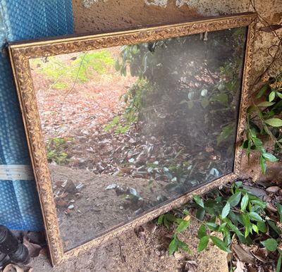 un miroir posé par terre devant un rideau bleu