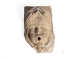 a stone sculpture of a woman ' s face on a white surface