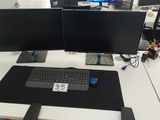 un bureau équipé de deux écrans et d'un clavier