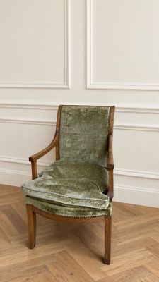 une image représentant une chaise verte posée sur un parquet en bois massif
