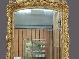 un miroir à cadre doré accroché au mur de la pièce