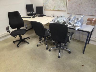 deux chaises de bureau noires et une table blanche dans une pièce