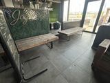 deux bancs en bois dans une pièce dotée de grandes fenêtres