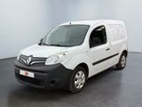 La camionnette blanche est garée dans une grande pièce au sol noir.