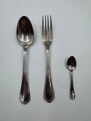 trois cuillères et une fourchette sur une table blanche