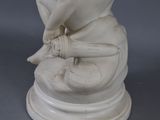a white statue of a child holding a baseball bat