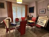 a room with a table, chairs, and pictures on the wall
