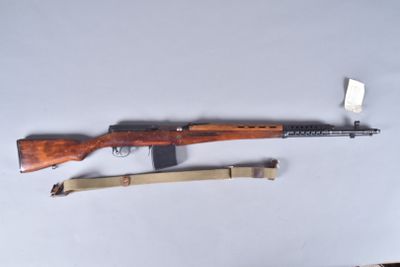a rifle and a knife on a table next to each other