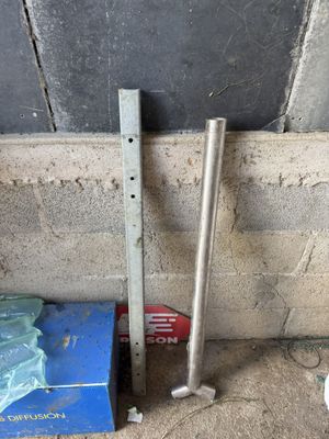 two pieces of metal on the ground next to a wall