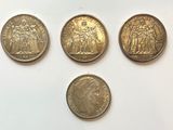 four different types of coins sitting on a white surface