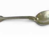 cuillère en argent avec un manche en forme de cœur sur un fond blanc