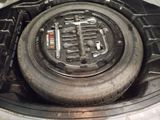 a tire in the trunk of a car with a wrenet