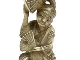 silver statue of a man holding a fan and a fan in his hand
