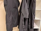 two coats hanging on a clothes rack in a closet