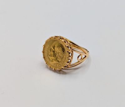 a close up of a gold ring with a coin on it