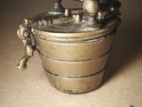a small metal container with a handle on a table