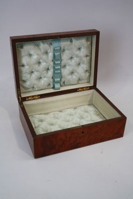 une petite boîte en bois contenant un tas de boules blanches
