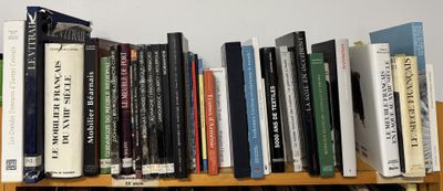 many books that are on a wooden shelf
