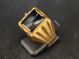 une image représentant une bague en or sertie d'une pierre noire