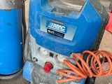 a blue air compressor sitting on the ground next to a blue fire hydrant