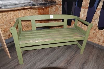 un banc vert dans une pièce au sol en parquet