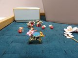 a lot of small figurines on the floor next to a box