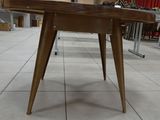 a table with a wooden top on a tile floor
