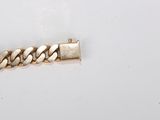 a close up of a gold chain bracelet on a white surface