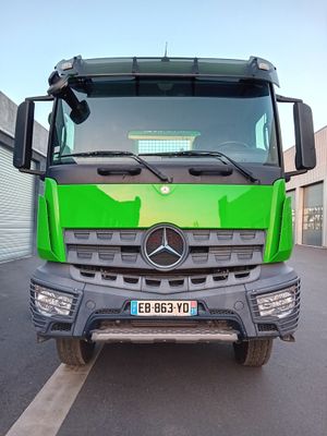 un camion vert garé sur un parking