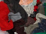 a pile of clothes that is sitting on a bed