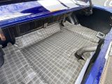 une voiture bleue avec un tapis de sol à carreaux dans le coffre