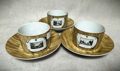 trois tasses à café et leurs soucoupes, ornées de motifs, posées sur une table