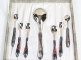 six cuillères et une cuillère-cuillère dans une boîte