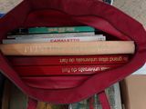 un sac rouge rempli de livres posé par terre