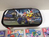 a nintendo mario kart carrying case next to several other nintendo games