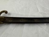 a very old sword that is laying on a white table