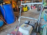 une photo d'un garage avec une tondeuse à gazon et d'autres outils