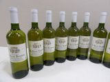six bottles of wine are lined up in a row on a table