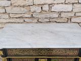 a marble top table with a black and gold design