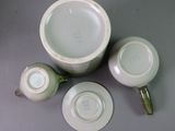 three cups and a saucer sitting on a table