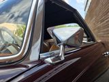 a close up of a car ' s side mirror with a brick wall in the background