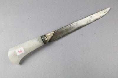une image représentant un couteau posé sur une table, avec une étiquette dessus