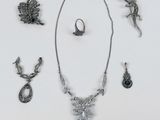 beaucoup de bijoux en argent sur une surface blanche