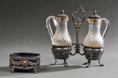 deux vases en argent et en verre et un bol posés sur une table