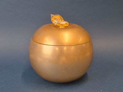 une pomme dorée surmontée d'une feuille