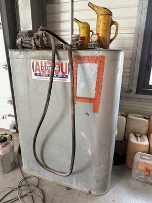 a gas tank with a hose attached to it in a garage