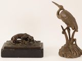a bronze statue of a bird and a dog on a stand