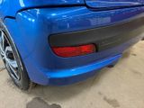 the rear end of a blue car in a garage
