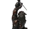bronze statue of a man holding a sword and sitting on a lion