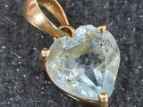 une photo d'un pendentif en topaze bleue en forme de cœur, monté sur une chaîne plaquée or
